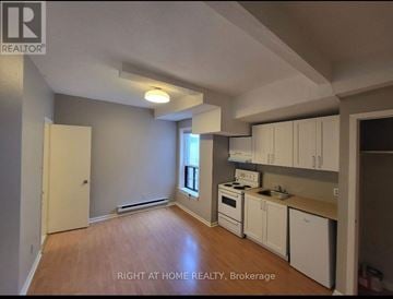 Toronto (South Riverdale) apartment for rent - A kitchen with white cabinets and a stove top oven.