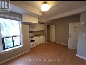 Toronto (South Riverdale) apartment for rent - A kitchen with white appliances and wooden floors.