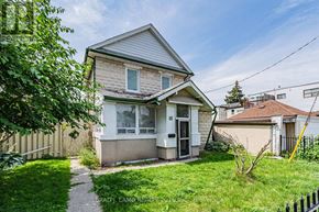 Toronto (East End-Danforth) apartment for rent - A house numbered 12 is surrounded by a green lawn and a fence.