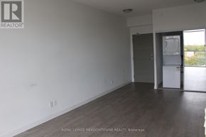 Toronto (Woodbine Corridor) condo for rent - A room with wooden flooring and white walls, with a door leading to another room.