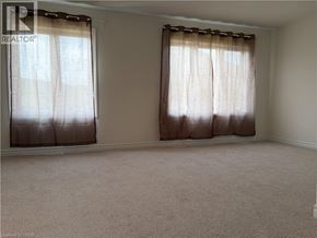 Ancaster townhouse for rent - A room with a window covered by brown curtains.