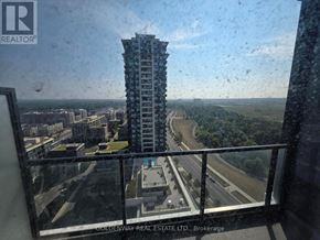 Markham (Unionville) condo for rent - A view from a high-rise building looking out over a highway and greenery.