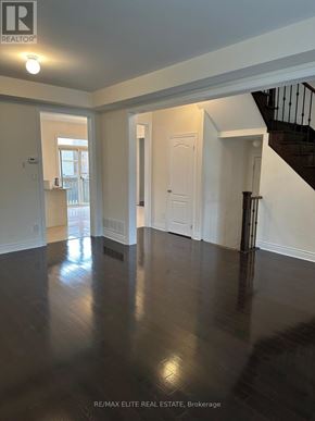 Newmarket (Stonehaven-Wyndham) apartment for rent - A spacious room with a staircase and a door leading to another room.