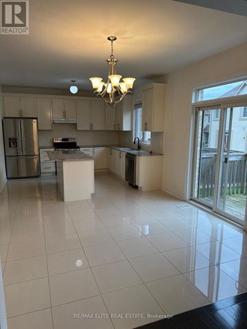 Newmarket (Stonehaven-Wyndham) apartment for rent - A kitchen with white tile floors and a chandelier hanging from the ceiling.