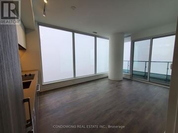 Vaughan (Vaughan Corporate Centre) condo for rent - A spacious room with wooden floors and large windows.