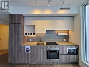 Vaughan (Vaughan Corporate Centre) condo for rent - A modern kitchen with wooden cabinets and a stainless steel oven.