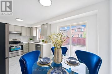 Brampton (Fletcher's Meadow) apartment for rent - A modern kitchen with blue chairs and a dining table set for two.