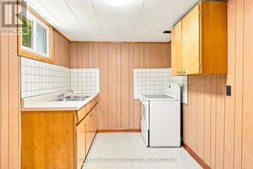 Niagara Falls (Arad/Fallsview) apartment for rent - A small kitchen with a sink and a washing machine.