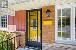 Niagara Falls (Arad/Fallsview) apartment for rent - A black door with a yellow frame is on a brick house.