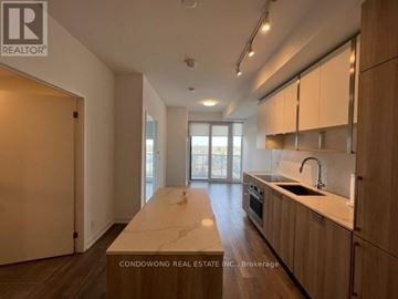 Toronto (Willowdale East) condo for rent - A kitchen with wooden cabinets and a marble countertop.