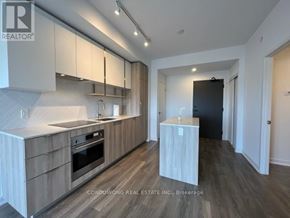Toronto (Willowdale East) condo for rent - A modern kitchen with wooden cabinets and a black refrigerator.