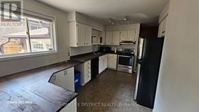 Oshawa (Centennial) apartment for rent - A kitchen with black and white appliances and cabinets.
