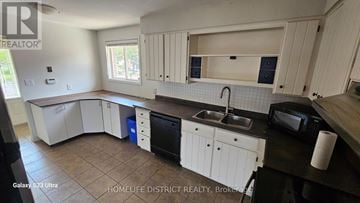 Oshawa (Centennial) apartment for rent - A kitchen with white cabinets and a black countertop.