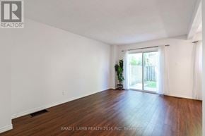 Mississauga (Mississauga Valleys) townhouse for rent - A room with wooden floors and white walls, with a plant and sliding glass door.