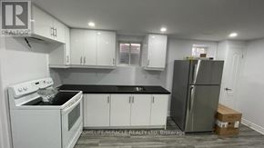 Mississauga (Meadowvale) apartment for rent - A white kitchen with a stove, microwave, and refrigerator.