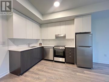 Toronto (Beechborough-Greenbrook) condo for rent - A kitchen with white cabinets and a stainless steel refrigerator.
