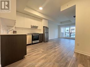 Toronto (Beechborough-Greenbrook) condo for rent - A kitchen with white cabinets and a wooden floor.