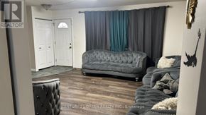 London South (South X) apartment for rent - A grey tufted couch sits in a living room with a white door and a window with blue curtains.