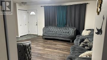 London South (South X) apartment for rent - A grey tufted couch sits in a living room with a white door and a window with blue curtains.