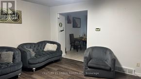 London South (South X) apartment for rent - A living room with a black couch and a grey armchair.