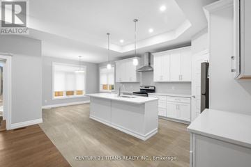 Chatham-Kent apartment for rent - A modern kitchen with white cabinets and a wooden floor.