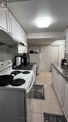 Markham (Royal Orchard) apartment for rent - A kitchen with white cabinets and a black stove top.