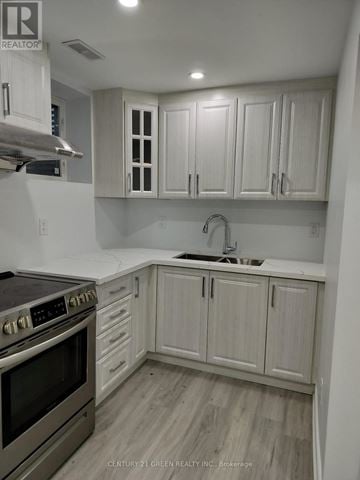 Milton (Be Beaty) apartment for rent - A kitchen with white cabinets and a stove top oven.