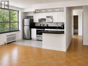 Toronto (Rosedale-Moore Park) condo for rent - A modern kitchen with black and white appliances and wooden floors.