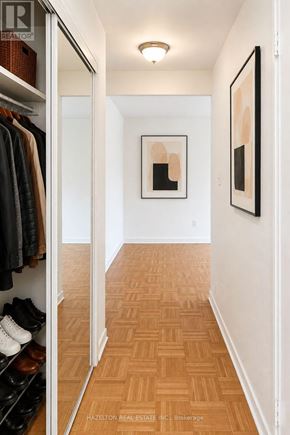 Toronto (Rosedale-Moore Park) condo for rent - A hallway with a wood floor and a white wall with a painting on it.