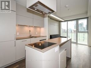 Toronto (Waterfront Communities) condo for rent - A modern kitchen with white cabinets and a large island.
