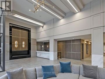 Mississauga (Creditview) condo for rent - A modern living room with a grey couch and a wooden door.