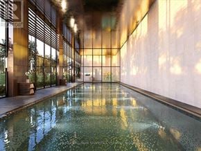 Toronto (Bayview Village) condo for rent - A long hallway with a pool in the middle and a wall on the right.