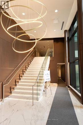 Toronto (Bayview Village) condo for rent - A staircase with a glass railing and a sign on the side.