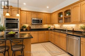 Toronto (Waterfront Communities) condo for rent - A kitchen with wooden cabinets and a black countertop.