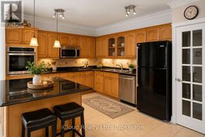 Toronto (Waterfront Communities) condo for rent - A kitchen with wooden cabinets and black appliances.