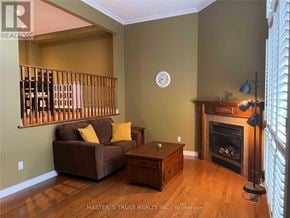 Markham (Royal Orchard) townhouse for rent - A living room with a brown couch, a wooden coffee table, and a fireplace.