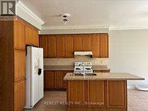 Brampton (Bramalea North Industrial) apartment for rent - A kitchen with wooden cabinets and a white refrigerator.