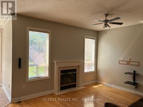 Brampton (Bramalea North Industrial) apartment for rent - A room with a fireplace and a ceiling fan.