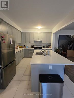 Woodstock (Woodstock - North) apartment for rent - A modern kitchen with a white island and wooden chairs.