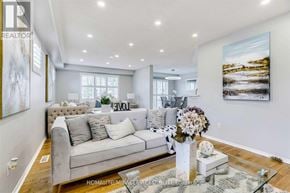 Brampton (Sandringham-Wellington) apartment for rent - A well-lit living room with a grey sofa and a large painting on the wall.
