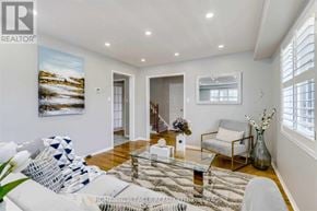 Brampton (Sandringham-Wellington) apartment for rent - A living room with a white sofa, a glass coffee table, and a painting on the wall.