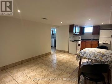 Burlington (Mountainside) apartment for rent - A kitchen with a table and chairs in the foreground and a refrigerator in the background.