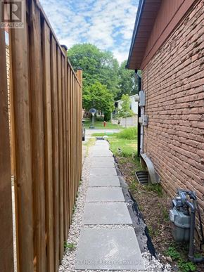 Mississauga (Meadowvale) apartment for rent - A wooden fence runs along the side of a brick building.