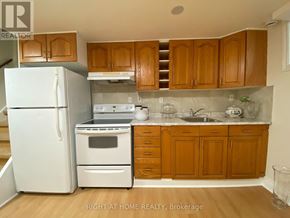 Mississauga (Meadowvale) apartment for rent - A kitchen with wooden cabinets and a white fridge.