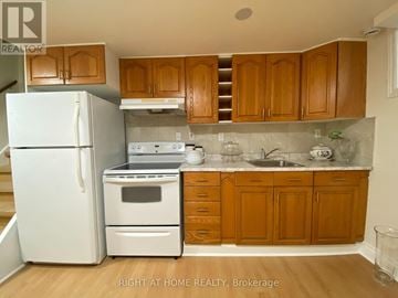 Mississauga (Meadowvale) apartment for rent - A kitchen with wooden cabinets and a white fridge.