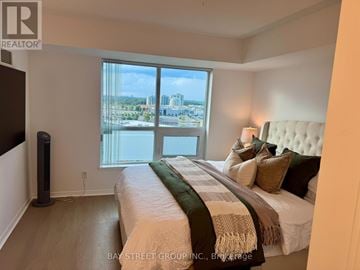 Mississauga (Central Erin Mills) condo for rent - A bedroom with a large bed and a view of the city.