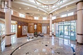 Mississauga (Central Erin Mills) condo for rent - A lobby with a marble floor and a ceiling with skylights.