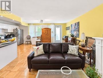 Toronto (Rosedale-Moore Park) condo for rent - A living room with a brown leather couch and a wooden cabinet.
