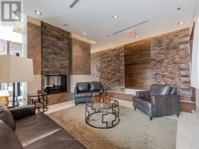 Pickering (Bay Ridges) condo for rent - A living room with a stone wall and leather furniture.