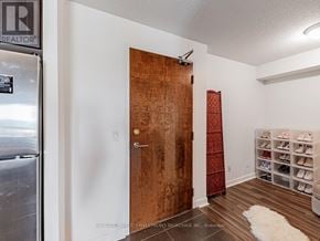 Pickering (Bay Ridges) condo for rent - A room with a wooden door and a shoe rack with multiple pairs of shoes.